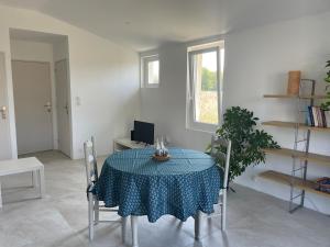 a dining room with a table and chairs with a blue table cloth at Préchacq-les-Bains in Préchacq