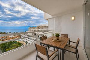 a dining room with a table and chairs on a balcony at Bella vista in Playa Fañabe