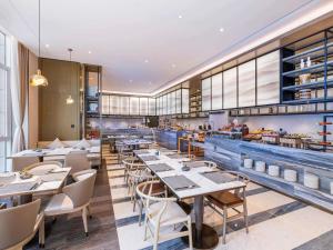 a restaurant with tables and chairs in a room at Novotel Shanxi Yuncheng in Yuncheng
