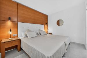 a bedroom with a large bed and a wooden wall at Bella vista in Playa Fañabe +5 photos