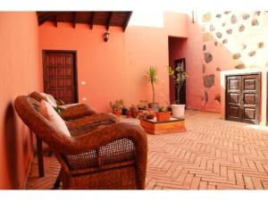 a living room with a wicker chair and a couch at Casa Rural los Ajaches in Yaiza