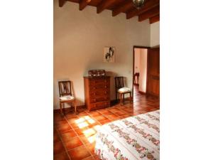 a bedroom with a bed and a dresser and two chairs at Casa Rural los Ajaches in Yaiza