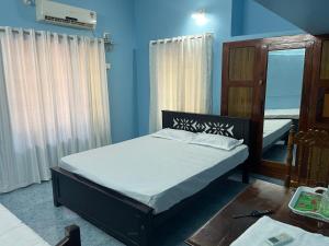 a bedroom with a bed in a room with blue walls at Bright Nest Service Villa Munroe in Kollam