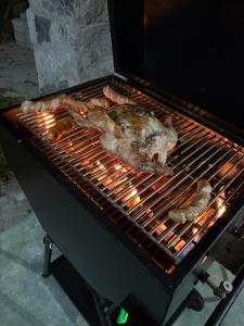 a chicken is cooking on a barbecue grill at Koshi's Country Cottage Ella in Ella