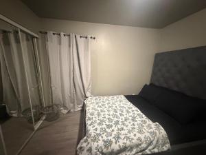 a bedroom with a bed with a white and blue blanket at Alvin Relax in El Cajon +25 photos