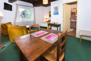 a living room with a wooden table and chairs at Auberge du Manoir d'Archelles in Arques-la-Bataille