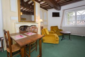 a room with a table and chairs and a fireplace at Auberge du Manoir d'Archelles in Arques-la-Bataille