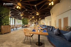 a restaurant with tables and a blue couch and chairs at 1404, Building 1, Ocean Sky Forest - Flamingo Cat Ba in Cat Ba