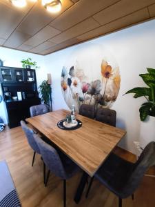 a dining room with a wooden table and chairs at Ferienwohnung Burgjuwel Burghausen nahe weltlängster Burg zentral 24h Check in in Burghausen