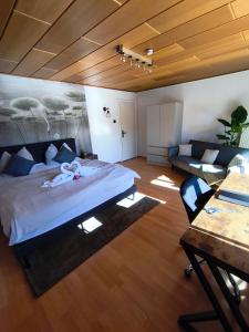 a bedroom with a large bed and a couch at Ferienwohnung Burgjuwel Burghausen nahe weltlängster Burg zentral 24h Check in in Burghausen
