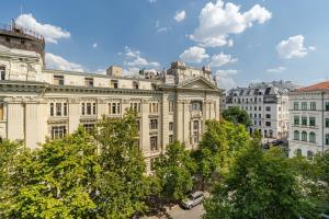 a large white building with trees in front of it at La Maison Parliament by BQA in Budapest