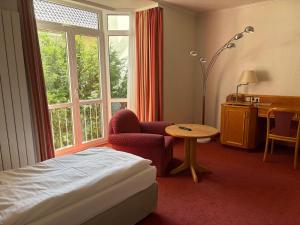 a hotel room with a bed and a table and a window at Boardinghouse am Wall in Salzgitter-Bad