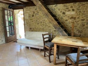 a dining room with a table and a bench at Chez Fayolle in Montagnac-la-Crempse
