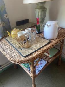 a wicker table with a tea set on it at Belmont-chambres  +14 photos