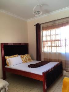 a bed in a room with a window at Kristina Gardens 1BD & Studio Homes in Voi