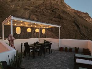 a table and chairs under a pavilion with a mountain at Casa Mussa in Valle Gran Rey