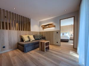 a living room with a couch and a bed at Weingut Santer Apartments in Mühlbach