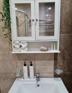a bathroom sink with a medicine cabinet and a mirror at Apartment Zdravets, in the heart of the old city in Veliko Tŭrnovo