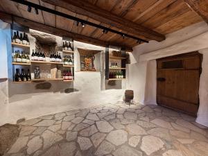 a room with a wall with bottles of wine at Weingut Santer Apartments in Mühlbach