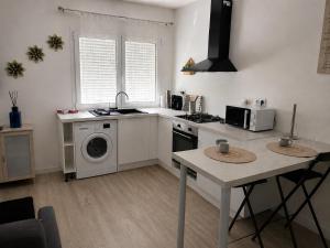 a kitchen with a stove and a washing machine at Patio in Gamarde-les-Bains