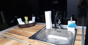 a kitchen sink with a soap dispenser and a basket at Átutazó Apartman in Nyíregyháza