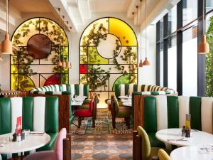 a restaurant with tables and chairs and stained glass windows at Mama Shelter Dubai in Dubai