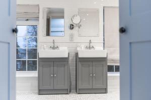 a bathroom with two sinks and a mirror at Monkey Island Estate - Small Luxury Hotels of the World in Windsor +50 photos