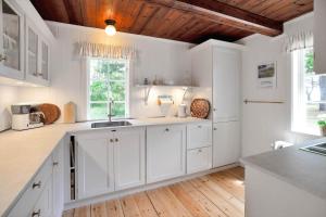 a kitchen with white cabinets and a wooden ceiling at 10081B-Rorvig-Skansehagevej-32 in Rørvig