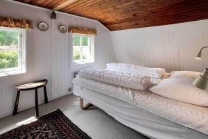 a white bedroom with a bed and two windows at 10081B-Rorvig-Skansehagevej-32 in Rørvig