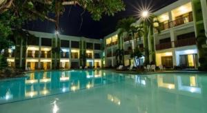 a large swimming pool in front of a building at night at Apple Tree Resort & Hotel in Opol