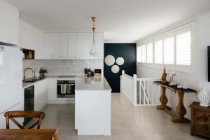 a kitchen with white cabinets and a counter top at La Ronde Three - Unit 3 - Oceanstays in Yamba