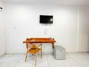 a desk with a chair and a television on a wall at Balian Paradise Hotel in Selemadeg