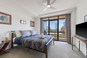 a bedroom with a bed and a flat screen tv at Akuna 14, 6 Joffre Street in Port Macquarie