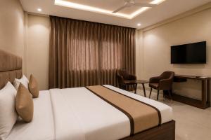 a hotel room with a bed and a desk at Hotel Elite La Prizm Near Zirakpur Bus Stand in Zirakpur