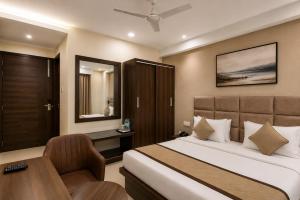 a bedroom with a bed and a desk and a chair at Hotel Elite La Prizm Near Zirakpur Bus Stand in Zirakpur