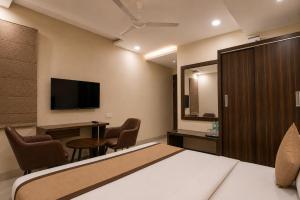 a hotel room with a bed and a desk and a tv at Hotel Elite La Prizm Near Zirakpur Bus Stand in Zirakpur +12 photos