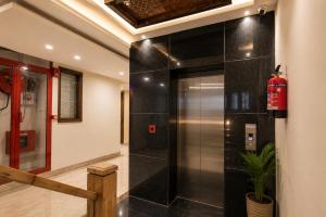 a elevator in a building with a fire extinguisher at Hotel Elite La Prizm Near Zirakpur Bus Stand in Zirakpur