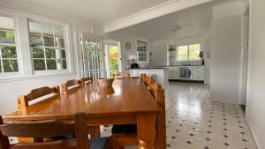 a dining room with a table and a kitchen at Allamanda House, 3 Willow Street in Crescent Head