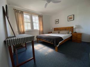 a bedroom with a bed and a chair in it at Allamanda House, 3 Willow Street in Crescent Head