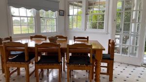 a dining room with a wooden table and chairs at Allamanda House, 3 Willow Street in Crescent Head +2 photos