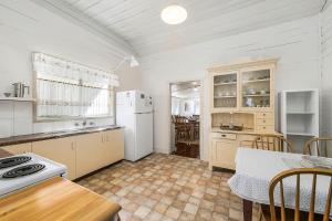 a kitchen with a white refrigerator and a table at Almare, 7 Gowing Street in Crescent Head