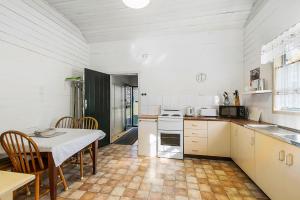a kitchen with a table and a table and chairs at Almare, 7 Gowing Street in Crescent Head +5 photos