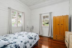 a bedroom with a bed and two windows at Almare, 7 Gowing Street in Crescent Head