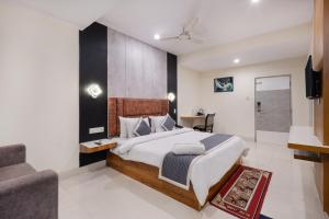 a bedroom with a large bed and a couch at The Orange Hotel in Visakhapatnam +20 photos