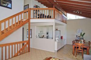 a living room with a staircase and a dining room at Bellevue Holiday House Crescent Head in Crescent Head