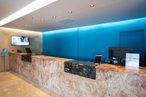 a lobby with a blue wall and a reception counter at BLUESEA Salina Ex MD Atlantic in Es Cana