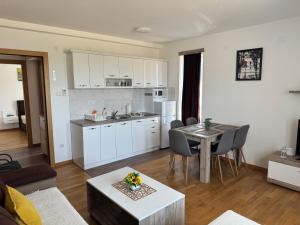 a kitchen and a living room with a table and chairs at KONAK ViLA MIRKOVIĆ in Soko Banja