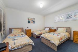 a bedroom with two beds and two windows at Breakers 2 in Crescent Head