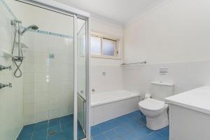 a white bathroom with a toilet and a shower at Breakers 2 in Crescent Head +14 photos