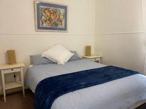 a bedroom with a bed and two night stands at Fleur Cottage, 7 Willow Street in Crescent Head